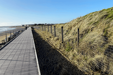 Sustainable coastal boardwalk protecting dune habitats from erosion in Cork County, Ireland.