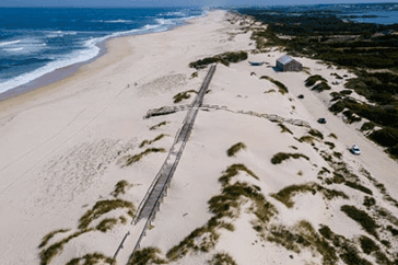 Drone view of a preserved sand dune system along the Portuguese coastline, showcasing nature-based solutions for coastal erosion and habitat conservation.