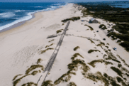 Drone view of a preserved sand dune system along the Portuguese coastline, showcasing nature-based solutions for coastal erosion and habitat conservation.