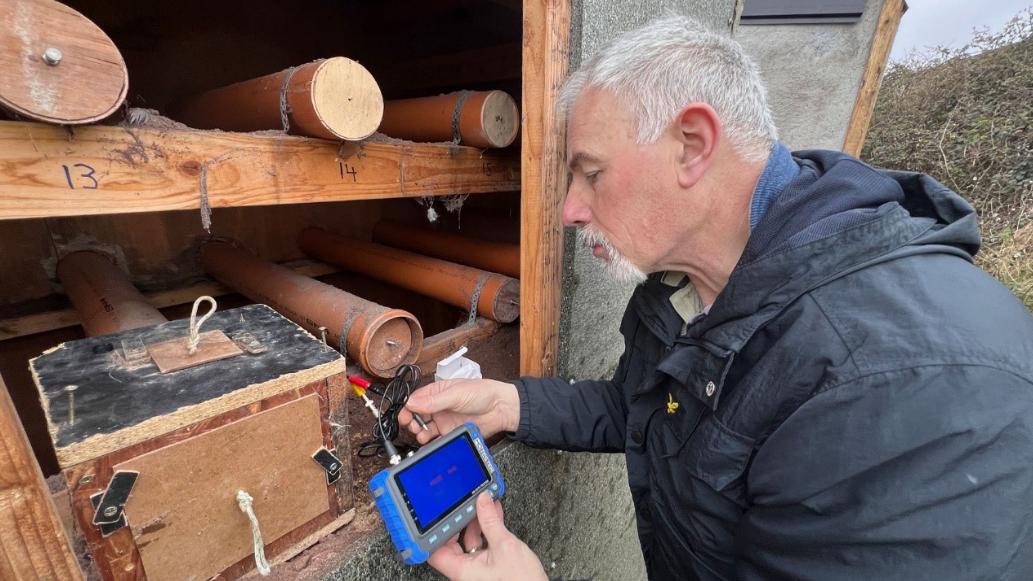 Wetland researcher conducting environmental monitoring with sensor equipment in Ireland